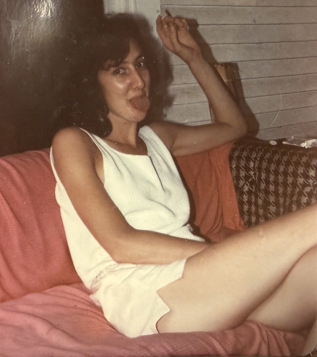 A woman lounging on a pink couch.