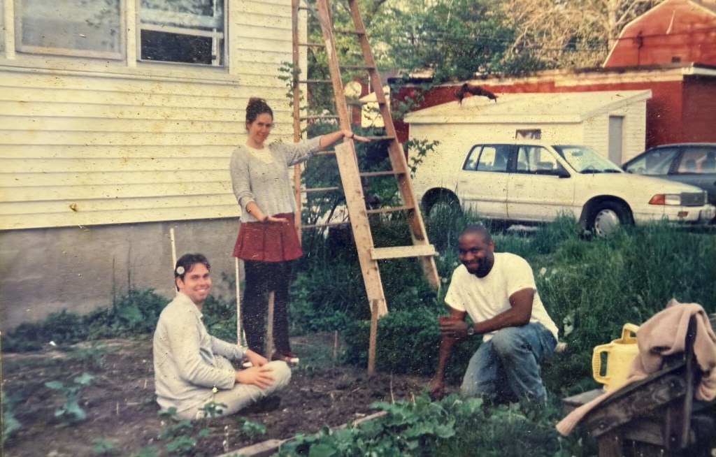 Four people gardening beside the house with a ladder against the wall.