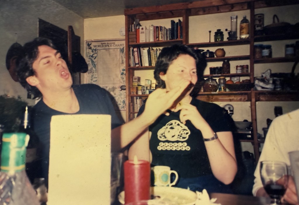 Two people at a table with a HOUSEWORK CHART on the shelves behind.