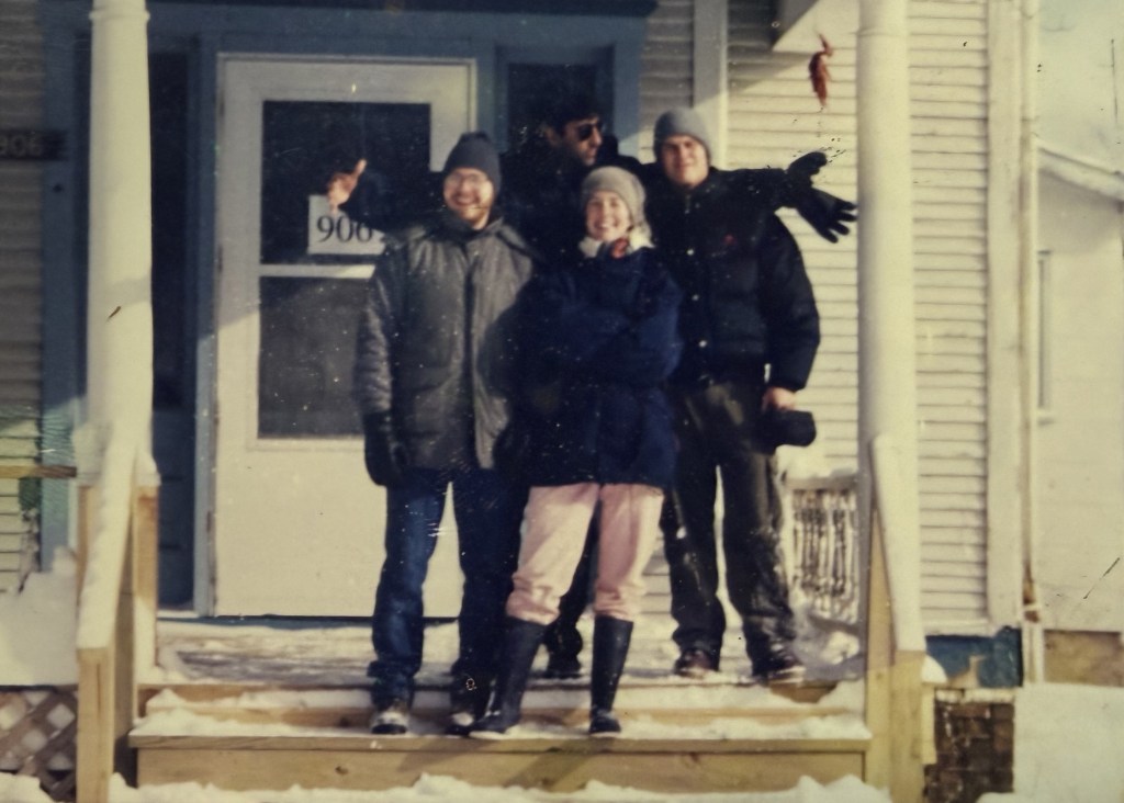 Four people on the snowy front steps.