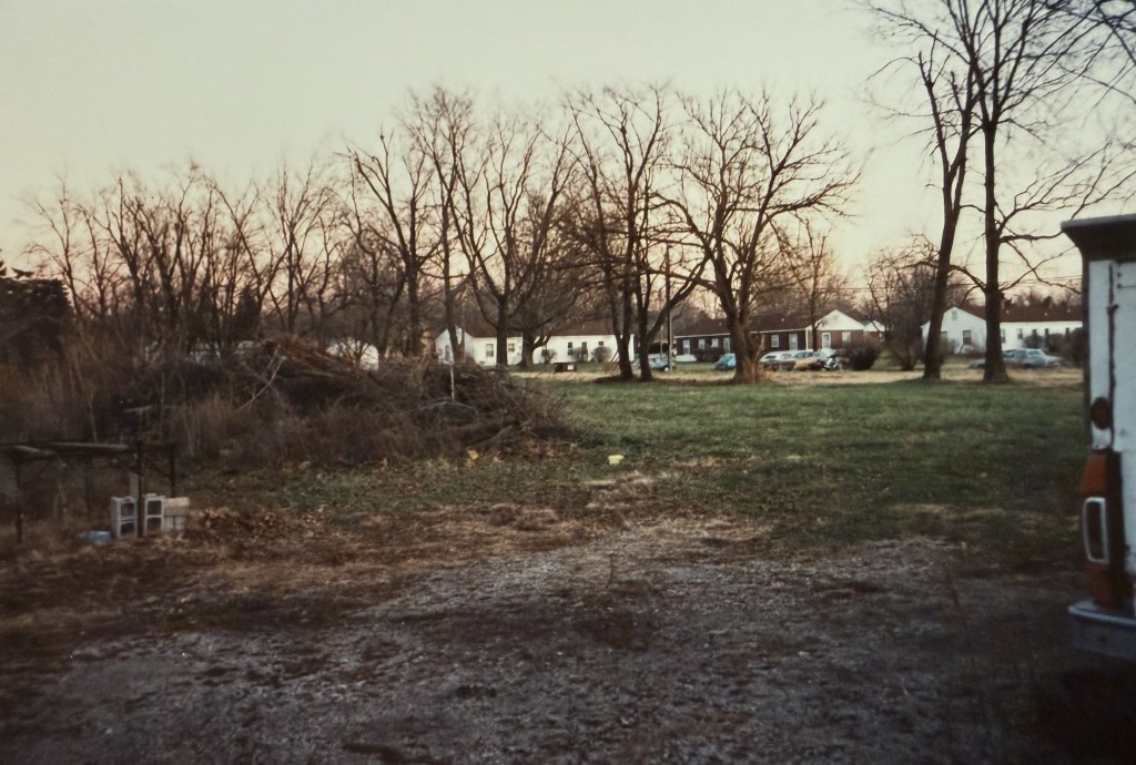 An open vacant lot with bare winter trees.