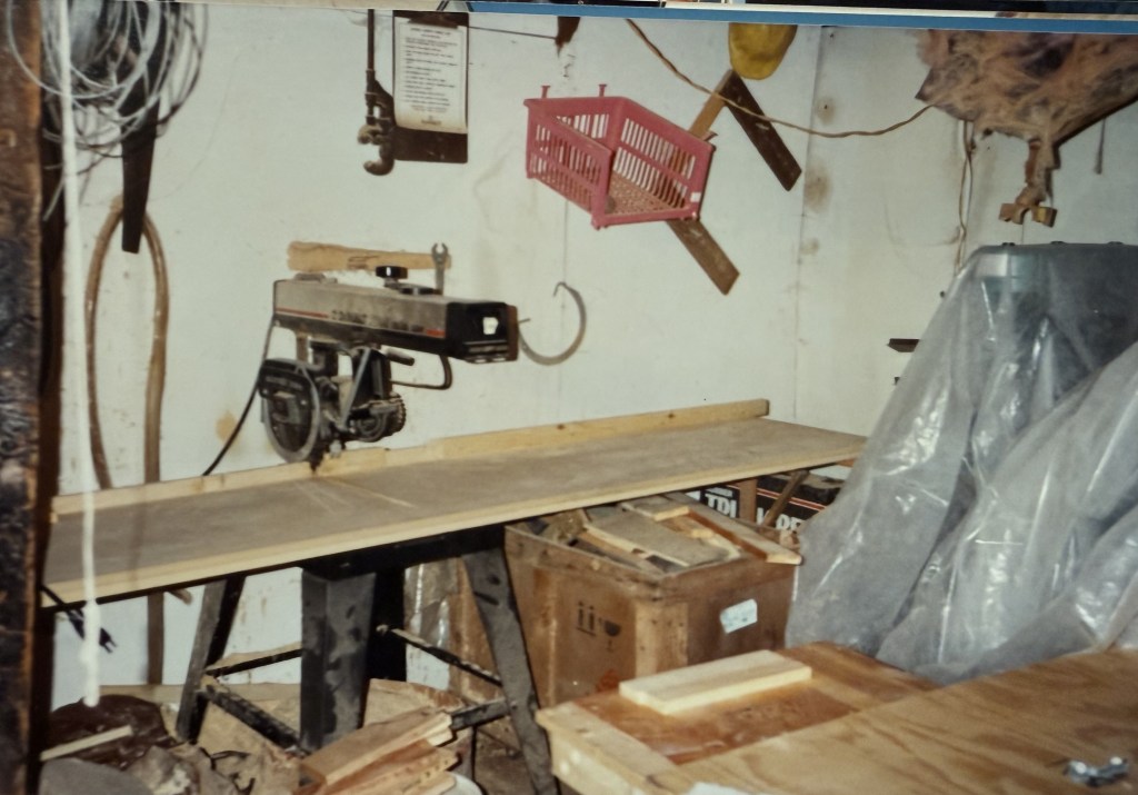 Workshop with a radial-arm saw and hanging tools.