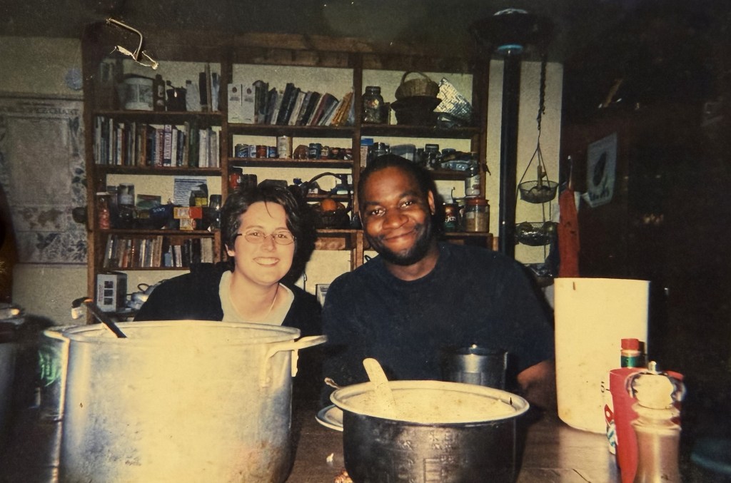 Two people behind two enormous stockpots.