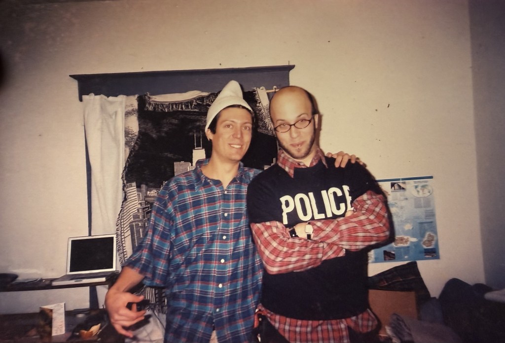 Two people, one in a pointed hat, one in a POLICE shirt.
