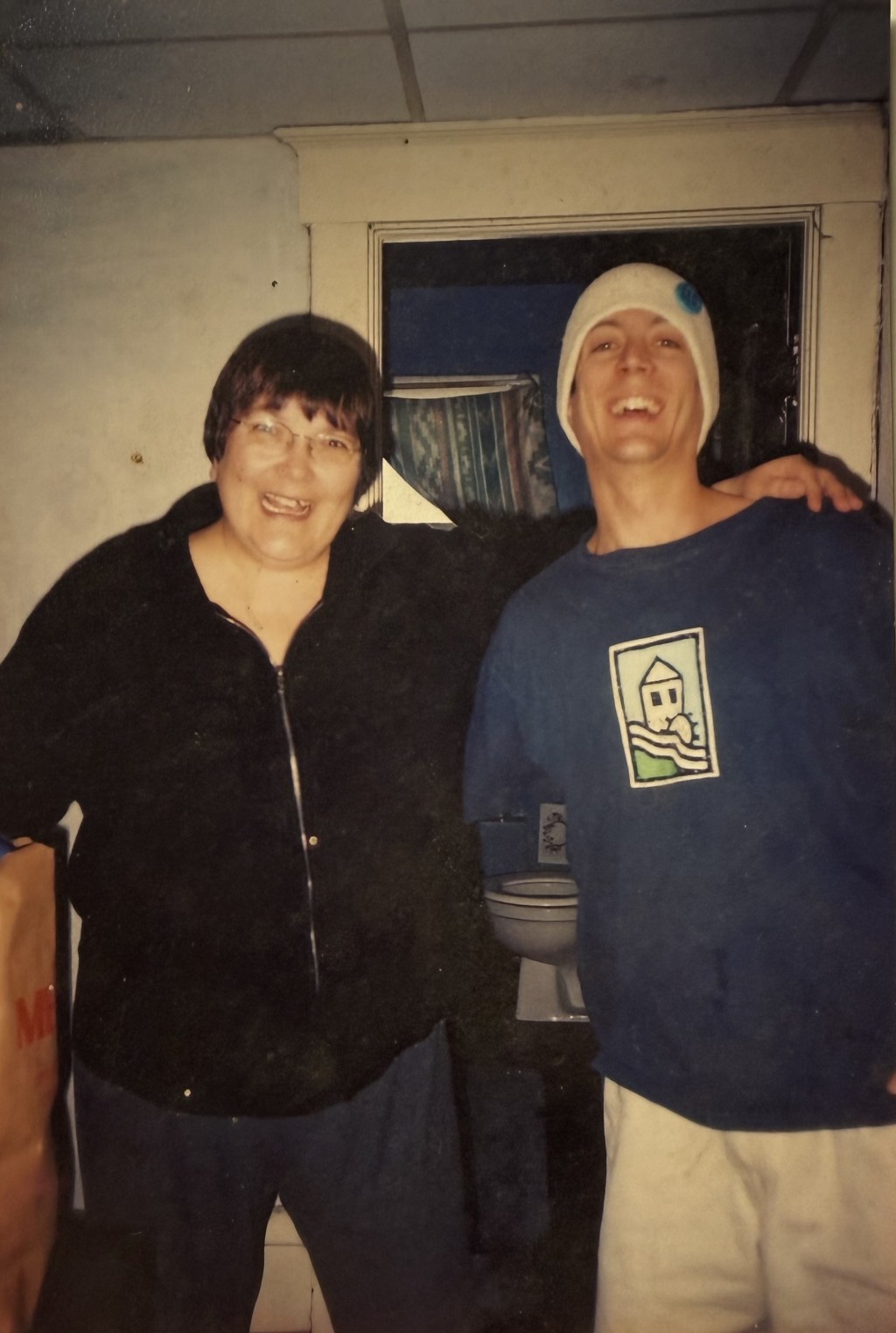 Two people arm in arm in a doorway.